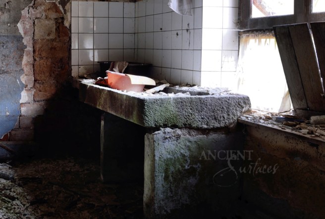 A massive antique thick slab sink seen with three supportive limestone legs.